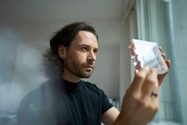 Creative Highlights Symbolbilder Confident businessman examining glass object in office model released, Symbolfoto, PNEF02927