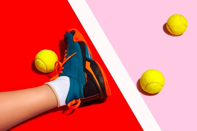 Creative Highlights Symbolbilder Leg of woman with shoe amidst yellow balls over colored background model released, Symbolfoto, RDTF00164