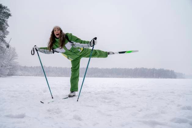 Excited woman balancing on one leg in snow model released, Symbolfoto, VPIF09511