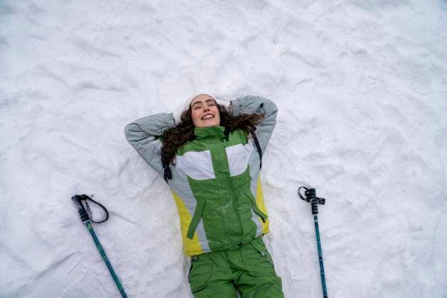 Creative Highlights Symbolbilder Happy woman with hands behind head lying on back in snow model released, Symbolfoto, VPIF09516