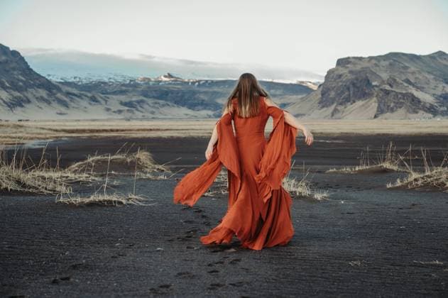 Creative Highlights Symbolbilder Woman in red dress walking in wild Icelandic landscape Hvolsvöllur, Rangárþing eystra, Iceland CR_FFVO240619F6-1464343-01 ,model released, Symbolfoto