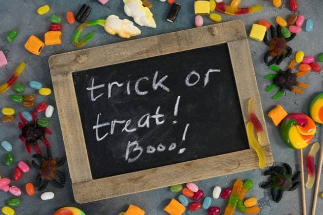 Colorful halloween candies on stone. Trick and treat letters in chalk on blackboard with colorful halloween candies on stone with copy space ,model released, Symbolfoto