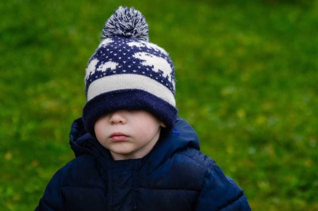 Child wearing a winter hat pulled over their eyes, standing outdoors Wingham, Ontario, Canada R_ATBL240617-1455725-01 ,model released, Symbolfoto