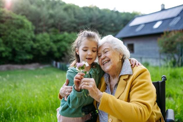 Granddaughter spending time with elderly grandma, picking wildflowers. Senior lady in wheelchair spending time in nature. Granddaughter spending time with elderly grandma, picking widlflowers. Senior lady in wheelchair spending time in nature. Weekend in cottage. model released