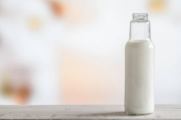 Bottle of milk standing on a wooden table ,model released, Symbolfoto