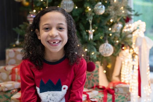 Portrait of smiling girl sitting in front of Christmas tree model released Copyright: xCulturaxCreativex