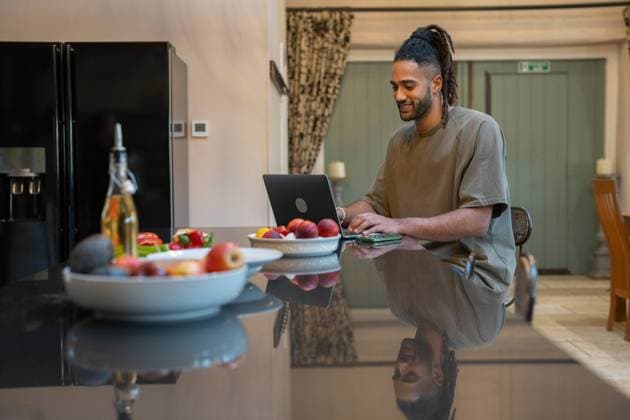 Man with dreads working on laptop at home model released Copyright: xCulturaxCreativex