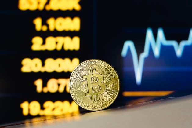 Bitcoin cryptocurrency in Paraguay - 03 Jul 2024 In this photo illustration, a Bitcoin is seen on the table with a stock market graph in the background. Paraguay Copyright: xJaquexSilvax xSOPAxImagesx JAQUESILVA_03072024-4094