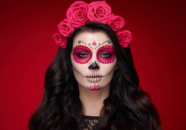 Portrait of a woman with sugar skull makeup over red background. Halloween costume and make-up. Portrait of Calavera Catrina ,model released, Symbolfoto