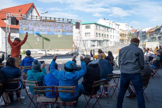 Fußballfans verfolgen anlässlich der Fußball-Europameisterschaft UEFA EURO 2024 das Viertelfinalspiel England gegen Schweiz auf einer Leinwand auf dem Platz Hlemmur in Rsykajvik. Soccer fans watch the quarter-final match between England and Switzerland on a screen at Hlemmur Square in Rsykajvik during the UEFA EURO 2024 European Football Championship. UEFA Fußball-Europameisterschaft - Fußballfans
