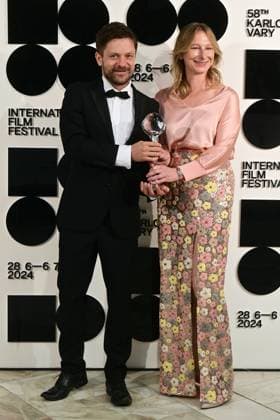 Director and actor Jiri Madl, left, and producer Monika Kristlova pose in front the photo wall with their Pravo Audience Award for the film Waves after the closing awards ceremony of the 58th Karlovy Vary International Film Festival, in Karlovy Vary, Czech Republic, on July 6, 2024. (CTKxPhoto SlavomirxKubes) CTKPhotoP2024070605420  CTKPhotoP2024070605420