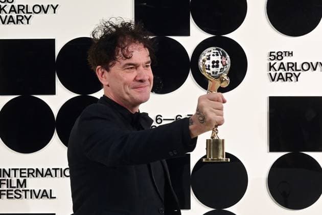 British director Mark Cousins poses in front the photo wall with his Crystal Globe for his film Sudden Glimpse of Deeper Things after the closing awards ceremony of the 58th Karlovy Vary International Film Festival, in Karlovy Vary, Czech Republic, on July 6, 2024. (CTKxPhoto SlavomirxKubes) CTKPhotoP2024070605709  CTKPhotoP2024070605709