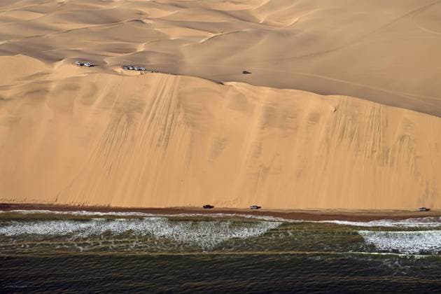 The Atlantic thunders in waves against the coast of the Namib Desert and cars are parked on the dunes, Sandwich Harbour, Namibia, Africa *** The Atlantic thunders in Waves against The Coast of The Namib Desert and Cars are parked ON The dunes, Sandwich Harbor, Namibia, Africa Copyright: imageBROKER ThomasxSbampato ibxtps10943581.jpg