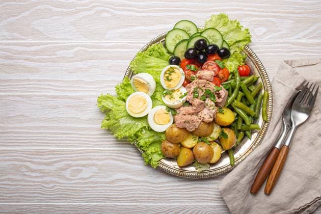 Nicoise salad with tuna, eggs, potatoes, green beans, and olives on a white table with copy space Delicious nicoise salad with tuna, eggs, potatoes, green beans, and olives on white wooden table with copy space Copyright: xZoonar.com OlenaxYeromenkox 21862184