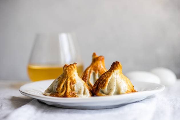 IMAGO Creative, Food, Dumplings Authentic Georgian khinkali dumplings served on a white plate, expertly cooked A clear glass of white wine complements the scene, heightening the culinary appeal Model Released AnnaBogush_ID22388_654127_006 Copyright: xAnnaxBogushx