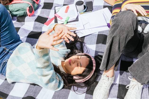 IMAGO Creative, Lifestyle, Frühling in der Stadt Three friends enjoying a sunny day outdoors while surrounded by study materials. One student is lying down, shielding her eyes, highlighting a relaxed atmosphere amidst academics Model Released IgnacioFerrandiz_ID22609_659660_022 Copyright: xIgnacioxFerrandizx RECORD DATE NOT STATED