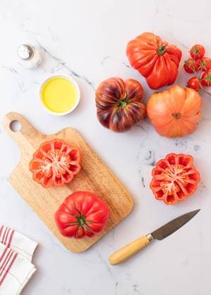 From above tomato salad preparation on wooden board with a knife, salt, olive oil and a selection of tomatoes Model Released OlgaVila_ID22383_654061_002 Copyright: xOlgaxVilax RECORD DATE NOT STATED
