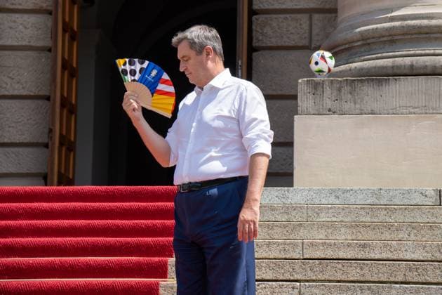 Ministerpräsident von Bayern Dr. Markus Söder bei der Ehrung der Freiwilligen Helfer der EM den Volunteers. Ihm ist heiß und er kühlt sich mit einem UEFA Fächer