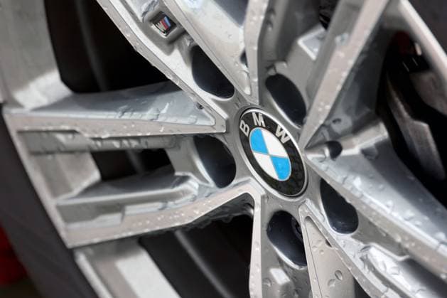 BMW Logo auf einem BMW Fahrzeug, Felge. Auf dem Logo und der Felge sind Wassertropfen. BMW am 12.07.2024 in Siegen Deutschland. *** BMW logo on a BMW vehicle, rim There are drops of water on the logo and the rim BMW on 12 07 2024 in Siegen Germany