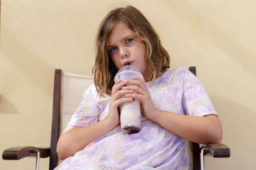 Creative Highlights Symbolbilder A blonde girl in a colorful dress drinking a refreshing fruit smoothie with a straw sitting on a chair 24897618 ,model released, Symbolfoto RECORD DATE NOT STATED