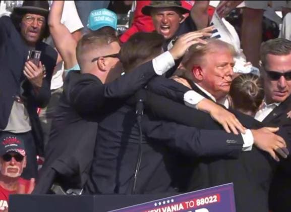 (240714) -- BUTLER, July 14, 2024 -- This video screenshot shows former U.S. President Donald Trump being helped off the stage at a rally in Butler, Pennsylvania of the United States after what sounded like gunshots rang out through the crowd, July 13, 2024. Video footage showed that Trump was making a speech when popping sounds rang out over the rally. Screams could be heard in the crowd, and Trump was swiftly escorted off the stage by Secret Service agents. Blood could be seen on the side of his head and his ear. He was quickly escorted into a vehicle, and his motorcade has left the venue. Trump is currently safe and is expected to survive, NBC News reported, quoting senior law enforcement officials. The shooting incident at Trum 