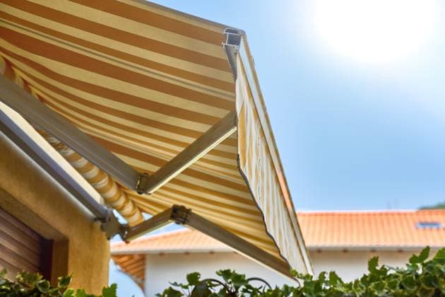 IMAGO Creative, Jahreszeit Sommer, Hitze Nago-Torbole, Lake Garda, Italy - 15 July 2024: Awning on a vacation apartment on Lake Garda offers optimum sun protection and increases outdoor living comfort. Awning provides pleasant shade and a cozy ambience on the terrace in Italy *** Markise an einer Ferienwohnung am Gardasee bietet optimalen Sonnenschutz und erhöht den Wohnkomfort im Außenbereich. Markise sorgt für angenehmen Schatten und ein gemütliches Ambiente auf der Terrasse in Italien