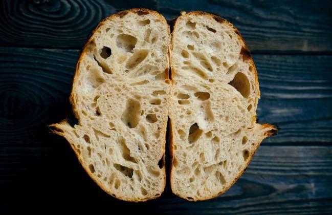 Freshly baked homemade tartine bread on dark wooden table ,model released, Symbolfoto