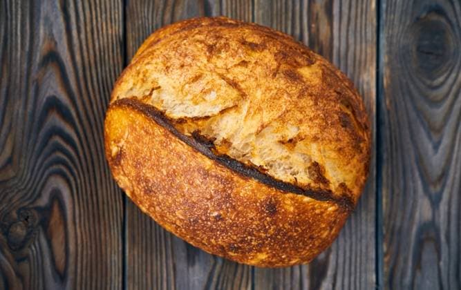 Freshly baked homemade tartine bread on dark wooden table ,model released, Symbolfoto