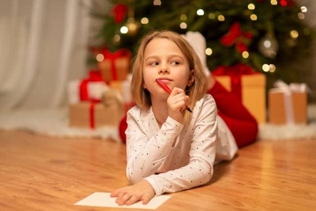 christmas, holidays and childhood concept - girl writing wish list or letter to santa at home. girl writing christmas wish list at home ,model released, Symbolfoto