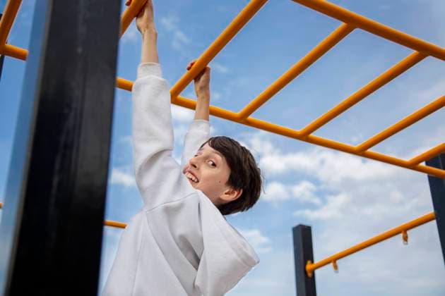 Creative Highlights Symbolbilder Cheerful Child playing on playground fun on monkey bars ?zmir, ?zmir, Türkiye R_THNZ2407169B-1486584-01 ,model released, Symbolfoto
