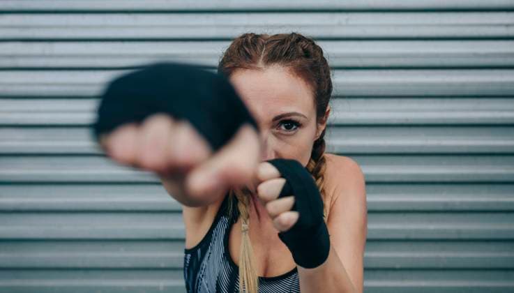 Creative Highlights Symbolbilder Sportswoman looking at camera and punching Young sportswoman with boxing bandages looking at camera and punching. Focus on face in background Model Released DavidPereiras_ID22352_653097_015 Copyright: xDavidxPereirasx