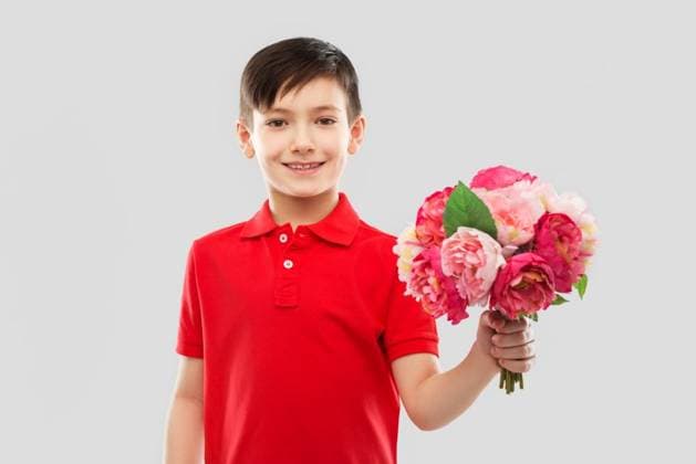 birthday, childhood and people concept - smiling little boy in red polo t-shirt with bunch of peony flowers over grey background. smiling boy with bunch of peony flowers ,model released, Symbolfoto