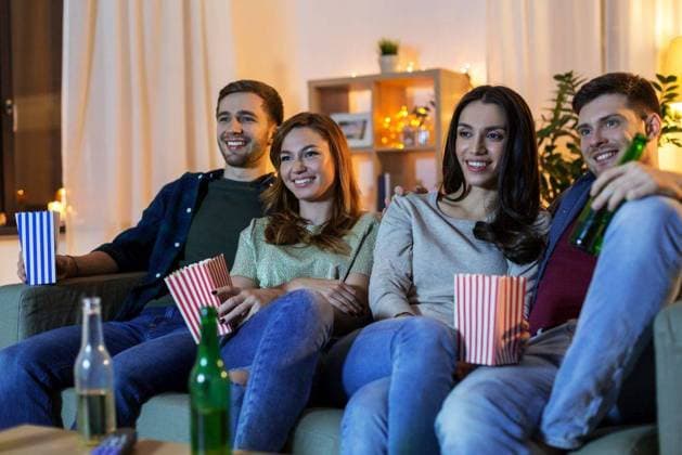 friendship and leisure concept - happy friends with beer and popcorn watching tv at home at night. friends with beer and popcorn watching tv at home ,model released, Symbolfoto
