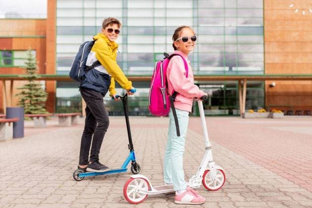 IMAGO Creative, Jahreszeit Herbst, Ferien education, childhood and people concept - happy school children with backpacks riding scooters outdoors. school children with backpacks riding scooters ,model released, Symbolfoto