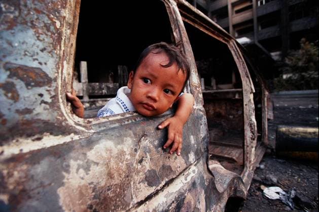 Archivbilder der Woche KW29 Attention: Date of recording according to label. Indonesia Children Indonesia Jakarta May 1998 small young child plays in burnt out car in the Chinese Sector Copyright: xAndrewxBuurmanx DMGTCHPDPICT000357927831