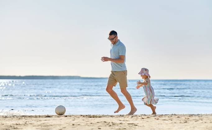 family, leisure and people concept - happy father and baby daughter playing ball on summer beach. happy father and daughter playing ball on beach ,model released, Symbolfoto