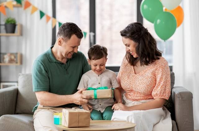 family, holidays and people concept - portrait of happy mother and father giving birthday present to little son sitting on sofa at home party. parents giving birthday present to little son ,model released, Symbolfoto