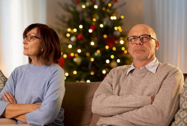 relationships difficulties, problem and people concept - unhappy senior couple sitting on sofa at home over christmas tree lights on background. unhappy senior couple at home on christmas ,model released, Symbolfoto