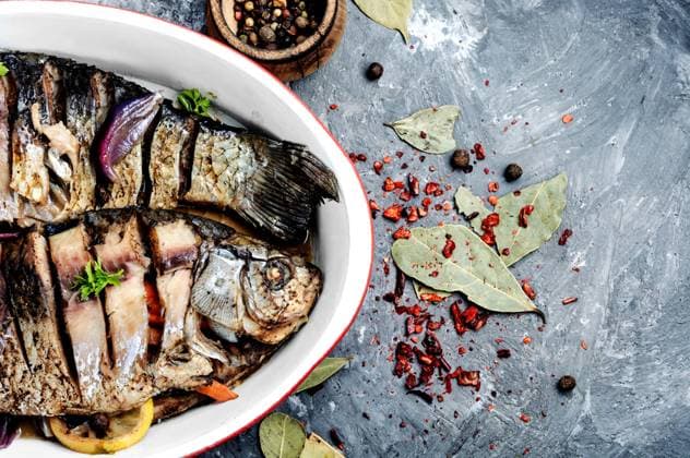 Baked fish loaded with citrus, herbs and spices in baked fish. Carp stuffed with vegetables ,model released, Symbolfoto