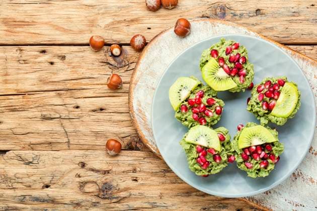 Diet avocado cupcakes garnished with kiwi and pomegranate.Cupcakes on wooden background. Cupcakes from avocado and kiwi. ,model released, Symbolfoto