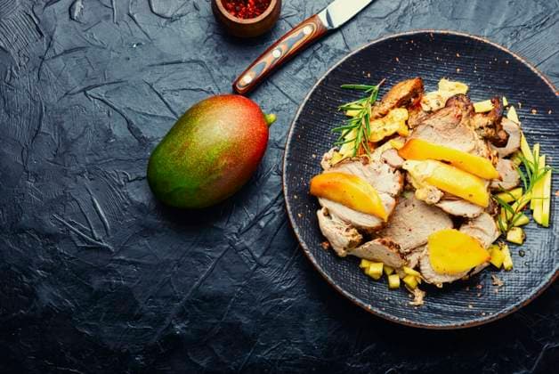 Delicious grilled meat with mango and cheese.. Fried pork with mango and cheese. ,model released, Symbolfoto