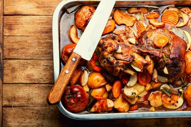 Pork knuckle or shank stewed in dark beer with quince and apples.Autumn meat recipe. Baked meat with autumn fruits ,model released, Symbolfoto