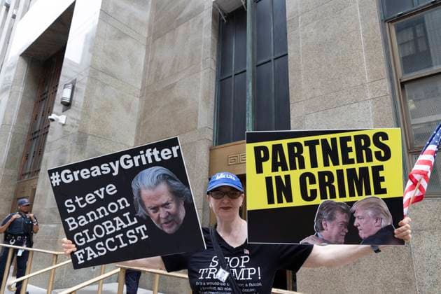 Bilder des Jahres 2024, News 07 Juli News Themen der Woche KW 30 News Bilder des Tages July 23, 2024, New York, New York, USA: An anti-Trump protester holds an American flag and signs with an image of Steve Bannon that reads GreasyGrifter Steve Bannon GLOBAL FASCIST and a sign with an image of Bannon and Trump together that reads PARTNERS IN CRIME outside of the Manhattan District Attorney s Office while awaiting a court appearance by Bannon (Not Pictured) for his fraud, money laundering and conspiracy case. New York USA - ZUMAr174 20240723_znp_r174_010 Copyright: xGinaxMxRandazzox