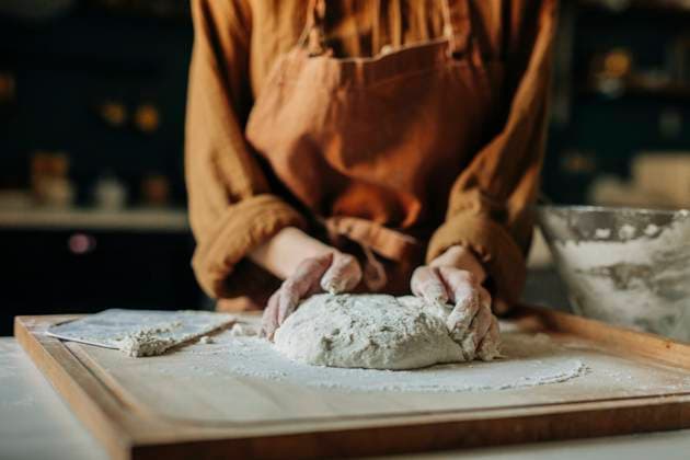 Hands of woman kneading dough on board at kitchen model released, Symbolfoto property released, VSNF02011