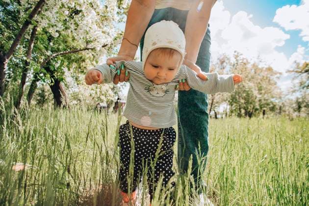 Baby girl walking with help of mother in garden model released, Symbolfoto, ADF00382