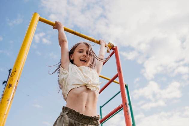 Creative Highlights Symbolfotos Playful girl hanging on monkey bar under cloudy sky model released, Symbolfoto, ANAF03330