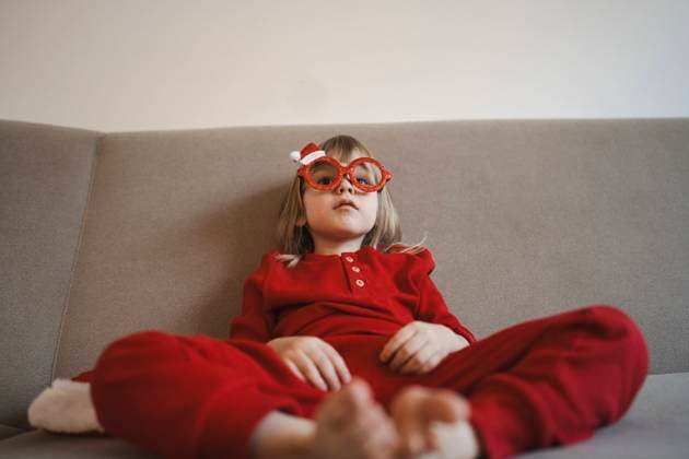 Confident girl with eyeglasses sitting on sofa at home model released, Symbolfoto property released, ASVF00068