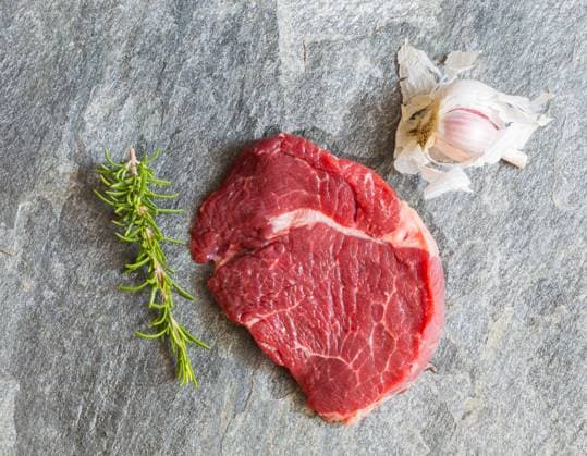 Raw beef steak with rosemary and garlic.. Raw beef steak with rosemary and garlic ,model released, Symbolfoto