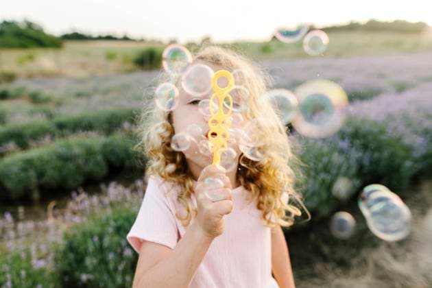 Creative Highlights Symbolfotos Playful girl blowing bubbles and standing in lavender field model released, Symbolfoto, SIF01132