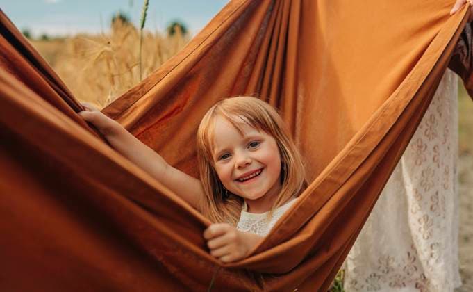 Creative Highlights Symbolfotos Smiling girl sitting inside brown sheet in wheat field model released, Symbolfoto, VSNF02160